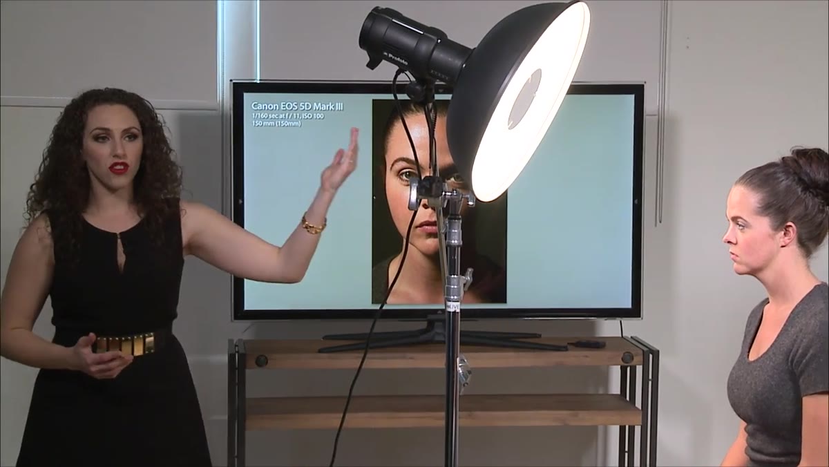 Instructor moving beauty dish closer to subject, approximately 2-4 feet away