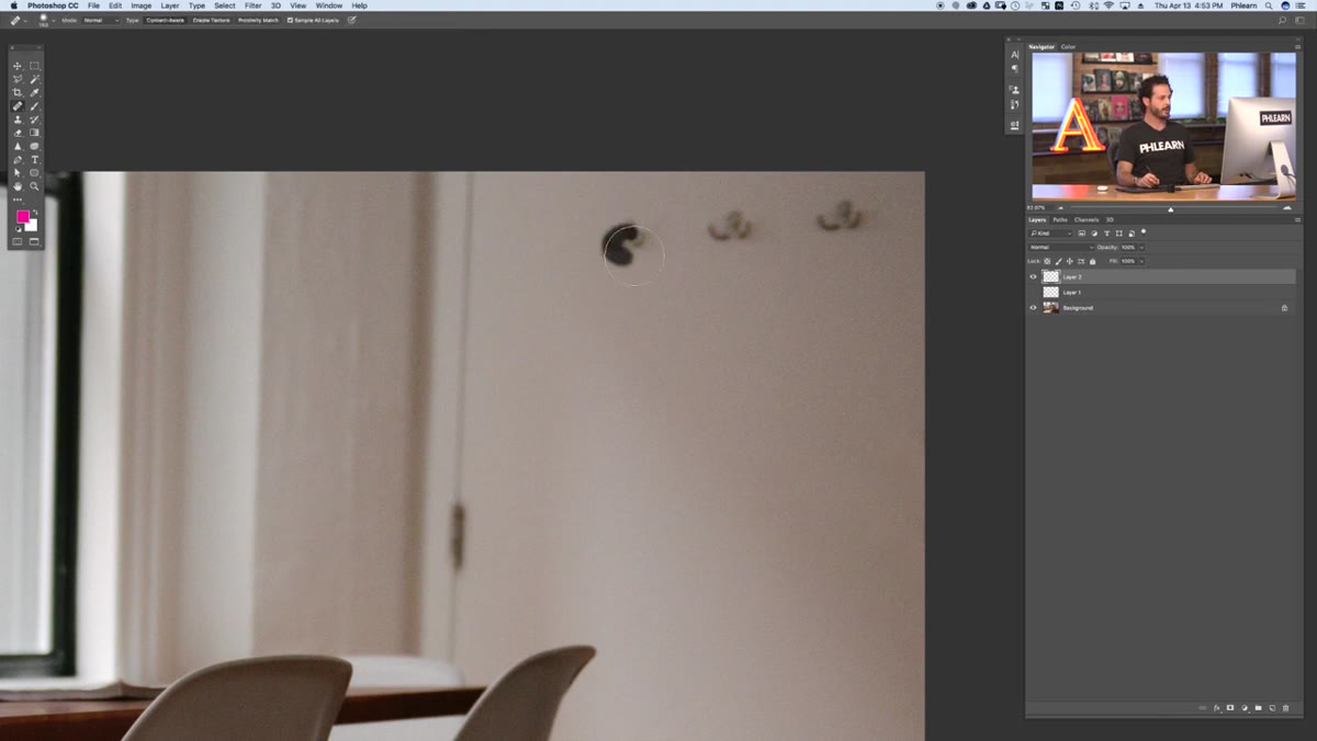caption: Spot healing brush painting over wall hooks