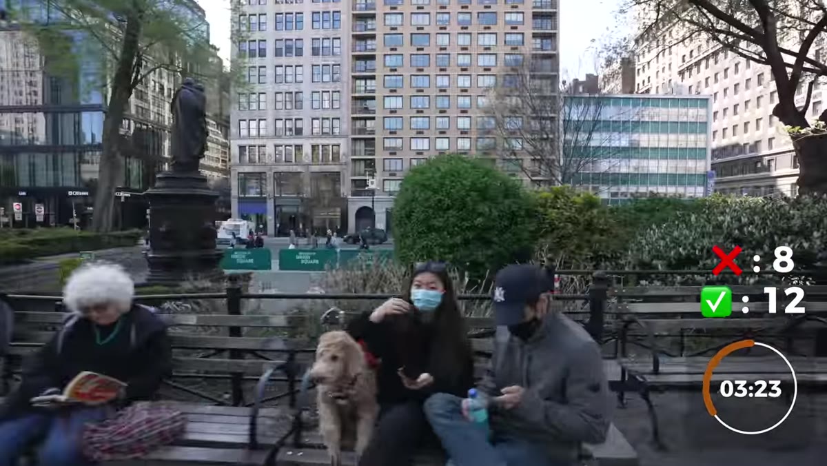Pierre photographs a subject with their dog, crowd nearby watching and smiling