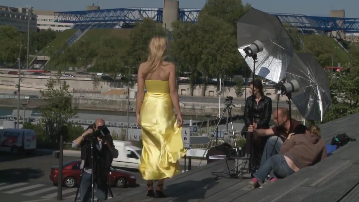 Model mid-step with dress flowing, photographer calling direction